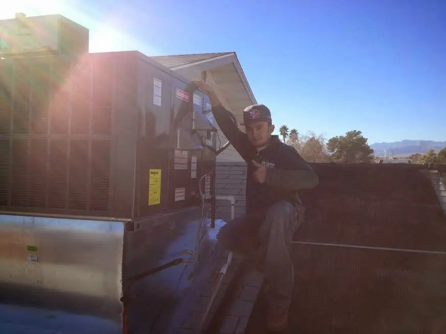 HVAC technician performing AC Tune-Up on a rooftop unit in Azusa